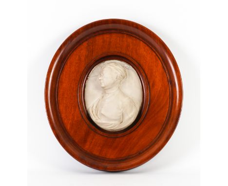 AN ENGLISH MARBLE RELIEF CARVED PORTRAIT MEDALLIONPossibly mid-18th Century Modelled wearing a cap, mounted in a later mahoga
