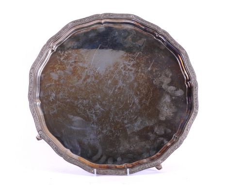 A SILVER SALVEROf shaped circular form, the border cast in a Celtic inspired design, raised on four feet, having mythological