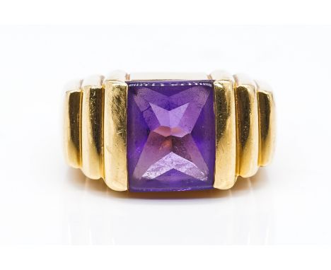 A GOLD AND AMETHYST SINGLE STONE RINGMounted with a rectangular amethyst, between stepped shoulders, detailed 750, ring size 