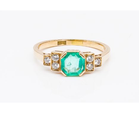 A GOLD, EMERALD AND DIAMOND RINGMounted with the octagonal step cut emerald between circular cut diamond three stone shoulder