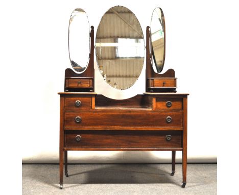 An Edwardian mahogany dressing table, replaced triplex mirrors, two raised trinket drawers over two short and two long drawer
