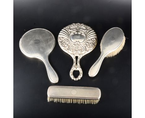 A matched set of silver backed engine turned mirror and two brushes, Lester &amp; Leafe, Birmingham 1922, plus a silver hand 