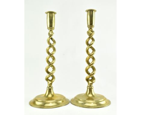 A pair of vintage barley twist brass candlesticks. Each featuring a barley twisted stem over stepped circular base. Measures 