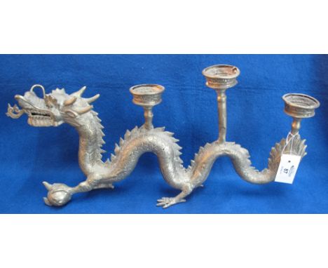 Oriental yellow metal candlestick in the form of a dragon, with three sconces, 56cm long approx. (B.P. 24% incl. VAT)