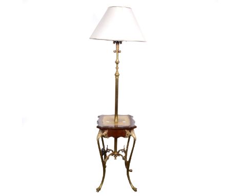 An Edwardian brass patent lamp table, adjustable column, the table top outlines in stained walnut on cast brass scrolled legs