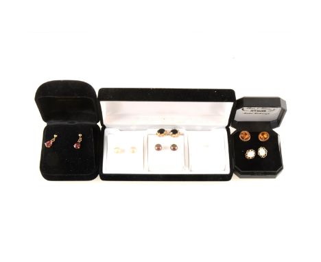 Seven pairs of earrings for pierced ears, three pairs of pearl button studs, garnet, opal, sapphire and golden quartz.