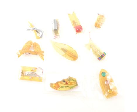 Ten Art Deco lucite dress clips and brooches, mostly in the "apple juice" and "lemon" colours, an arrow flight clip with circ