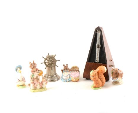 A German nickel-plated table lighter, in the form of a ship's wheel, 13cm; a metronome; and six Beswick Beatrix Potter figure