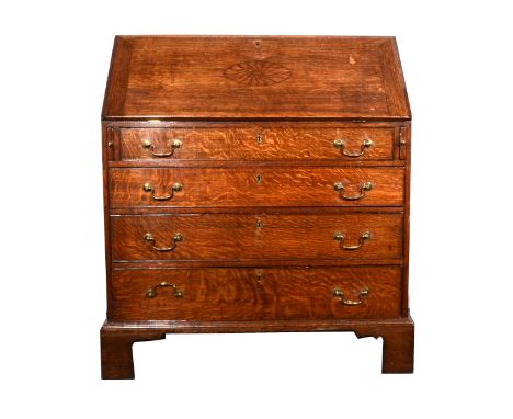 A Georgian oak bureau, later incised decoration to the fall front, enclosing a fitted interior, four long drawers below, brac