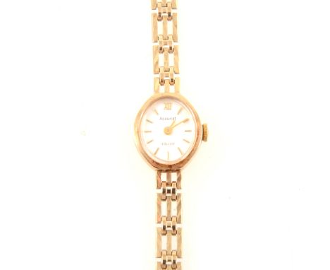 Accurist - a lady's 9 carat yellow gold bracelet watch, oval silvered baton dial in a 9 carat yellow gold case fitted with an