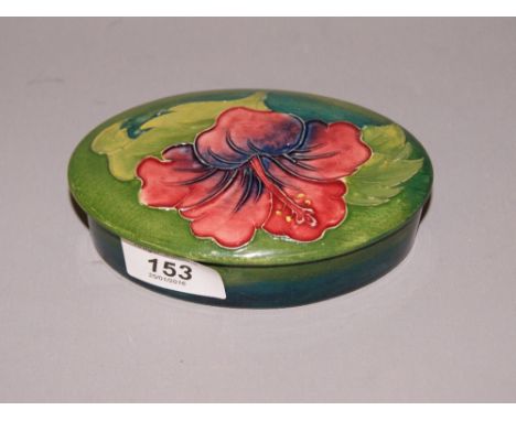 A Coral Hibiscus' oval lidded trinket pot by Moorcroft CONDITION REPORT; Available on request. Catalogue descriptions and con