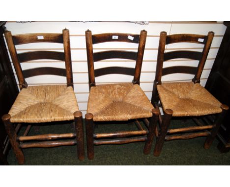 Three early oak ladder-back rush-seated chairs