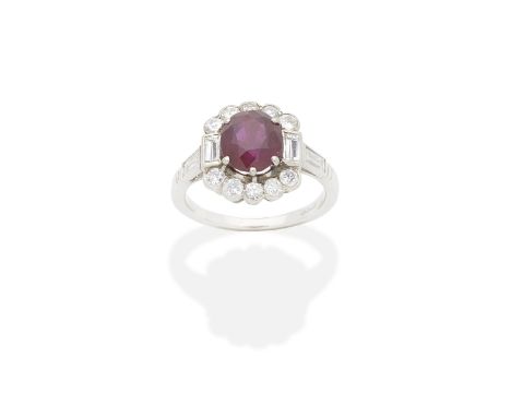 RUBY AND DIAMOND RINGThe oval-cut ruby within scalloped brilliant and baguette-cut diamond surround, ruby very approx. 2.50ct