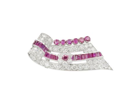 RUBY AND DIAMOND BROOCH, CIRCA 1950The scrolled ribbon of brilliant-cut diamonds and calibré and circular-cut rubies with cen
