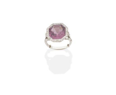 TOURMALINE AND DIAMOND RINGThe octagonal-cut tourmaline within a rose-cut diamond border, between fleur-de-lis shoulders, tou