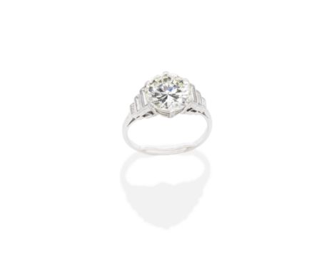 DIAMOND RINGThe brilliant-cut diamond, weighing 2.87 carats, between tapering baguette-cut diamonds, remaining diamonds appro