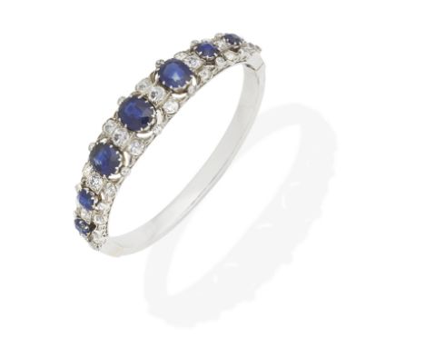 SAPPHIRE AND DIAMOND BANGLE, CIRCA 1890Set to the front with graduating cushion-shaped sapphires and old cushion-shaped diamo