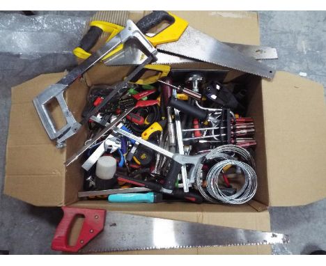 A box of various hand tools, saws, drill, screwdrivers, wrenches and similar.