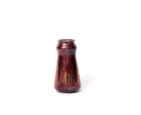 A Carter's Poole lustre vase designed by Owen Carter, tapering form with swollen neck and everted rim, covered with a ruby lu