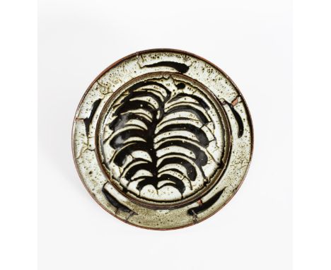 ‡ David Leach OBE (1911-2005) a Lowerdown Pottery charger, decorated to the well with a large leaf motif in tenmoku under Dol