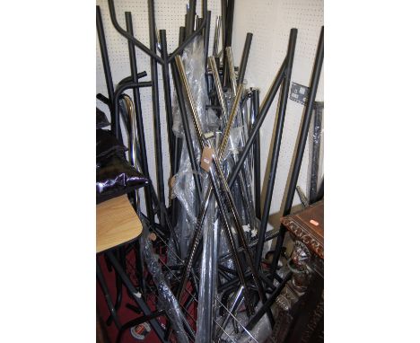 A collection of various contemporary tubular metal hanging clothes stands, mostly on roller castors