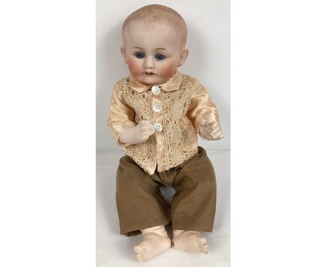 An antique 17.5" Nippon bisque headed boy doll with jointed composite body. With ceramic closing eyes and hand painted hair. 