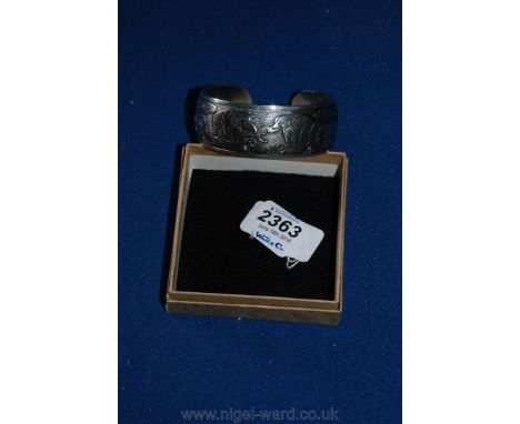 A silver coloured Bangle with white 'Chinese' marks