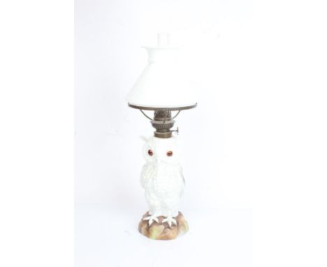 Continental porcelain oil lamp, the clear glass chimney and frosted white shade above an owl form body, modelled on a natural