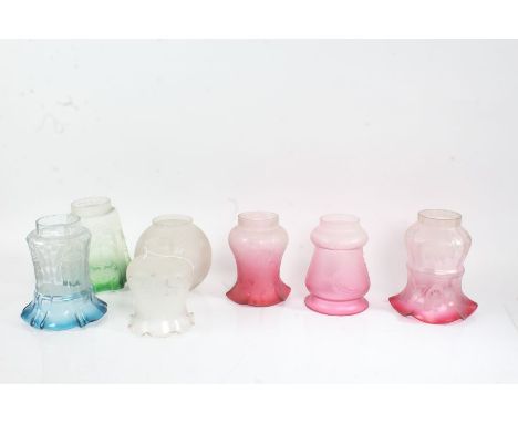 Seven frosted and clear glass lamp shades, to include three puce and frosted foliate decorated shades, a blue and clear glass