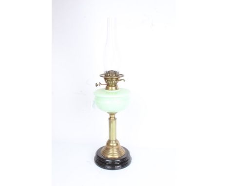 Best British Make oil lamp with clear glass chimney above a frosted green glass reservoir, raised on a reeded brass stem, ste