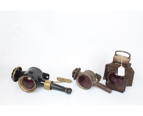 Sherwoods Ltd. Birmingham lamp, hand held candle lamp, ebonised and brass carriage style lamp, all with red lenses (3)