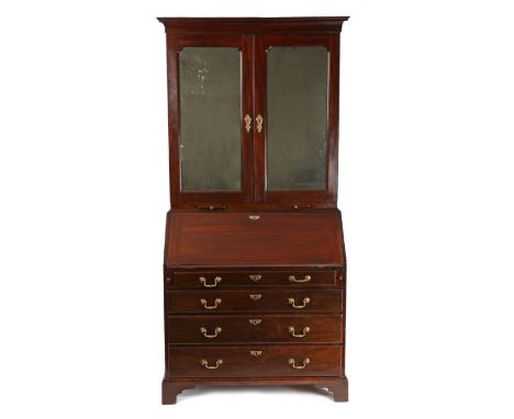 George III mahogany bureau bookcase, the concave pediment above a pair of mirrored doors enclosing adjustable shelves, pigeon