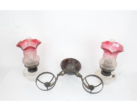 Hinks &amp; Son Birmingham wall mounted twin branch oil lamp, the scrolled acanthus leaf cast arms supporting the etched red 
