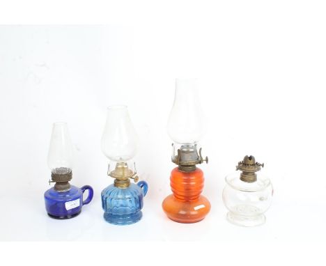 Three hand oil lamps, two with blue glass reservoirs, oil lamp with orange glass reservoir (4)