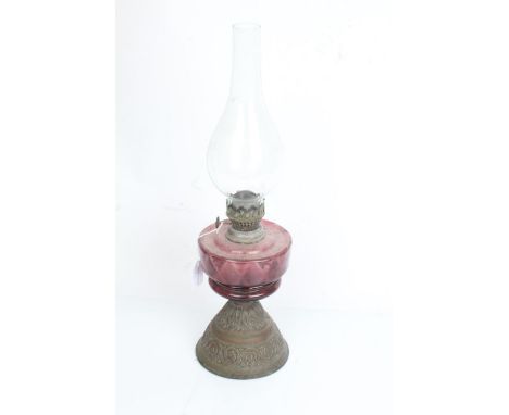 Venus Lamp Works oil lamp, with clear glass chimney and purple glass reservoir, on a scroll embossed copper foot, 52.5cm high