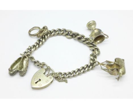 A silver charm bracelet, each link marked, with four charms including hallmarked silver galleon and trophy, 47g