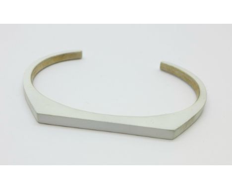 A silver Nin designer bangle, small sized