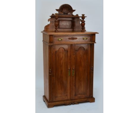 A c.1900 European pine side cabinet with raised shelf above single drawer, twin arch cupboard doors and a plinth base, width 