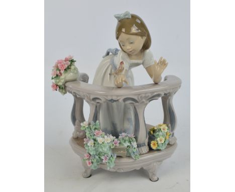 A Lladro figure of a girl on a balcony playing with a bird, height 23cm. CONDITION REPORT: A few minor losses to the petals a