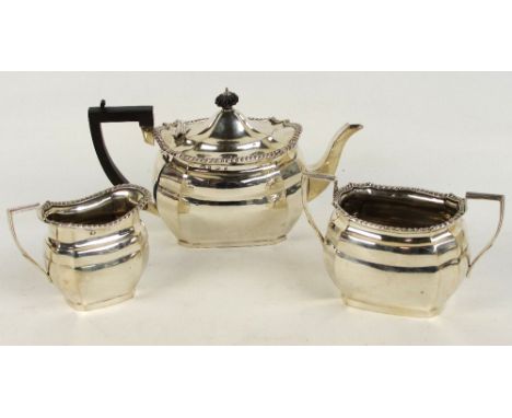 An Edwardian hallmarked silver three piece tea service of panelled rounded rectangular form, Birmingham 1905, length of teapo