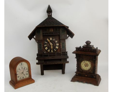 A large pine cased wall mounted cuckoo clock, the circular chapter ring set with Roman numerals beneath a tiled roof, length 