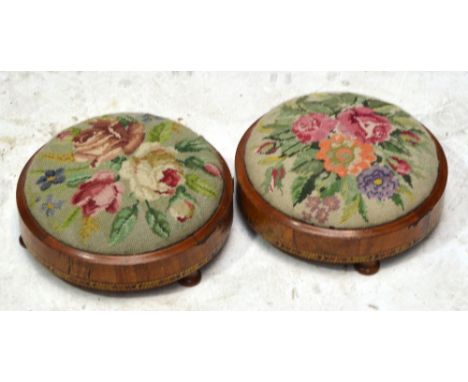 A pair of Victorian walnut and inlaid circular footstools upholstered with floral tapestry, raised on three pad feet, diamete