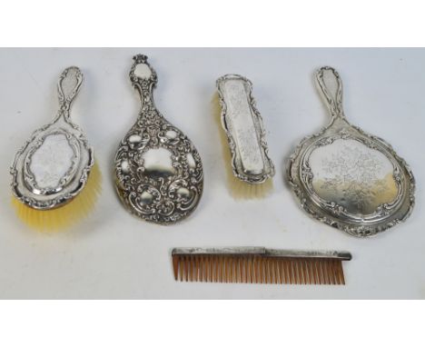 An Edwardian hallmarked silver mounted three piece dressing table set with engraved floral decoration, comprising a hand mirr