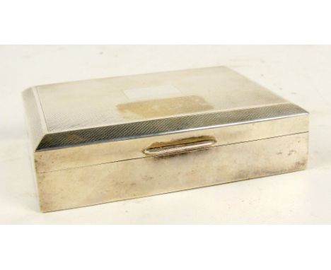 An Elizabeth II hallmarked silver cigarette box of rectangular form with engine turned decoration to the hinged lid centred w