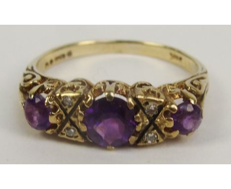 A 9ct gold Victorian style dress ring with three amethyst coloured stones in high decorative scrolling mount, size S, approx 