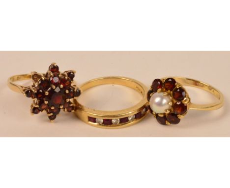 A 9ct gold garnet set floral ring, a further floral ring centred with a cultured pearl and a channel set ring (3).