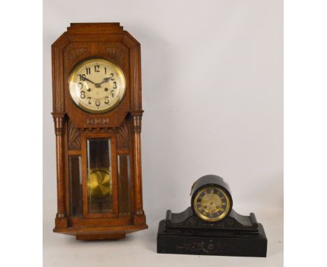 A late 19th century/early 20th century oak wall clock with three bevelled glass panels flanked by pilasters, the silvered dia