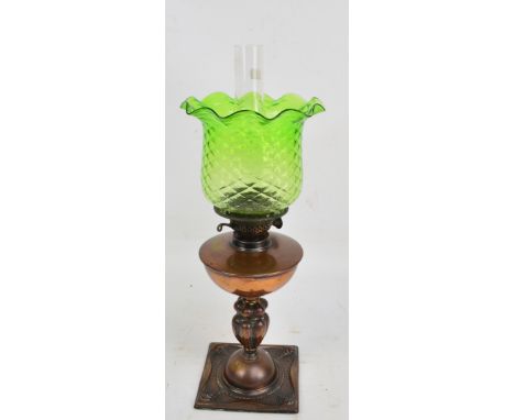 An Art Nouveau copper oil lamp with green glass shade, rounded reservoir, and embossed main column, height including chimney 