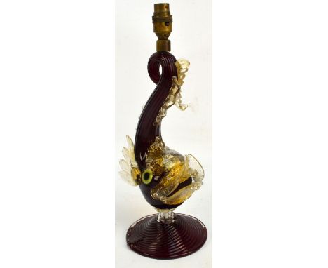 A c.1950s Murano ruby and clear glass lamp modelled as a dolphin, decorated with gold flakes and raised on spreading circular