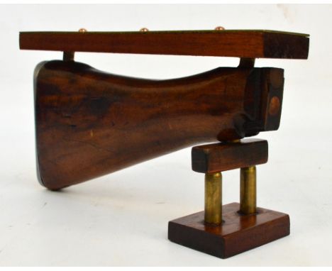 A brass and mahogany cribbage board mounted on a shotgun stock with an attached support, length 26.5cm.